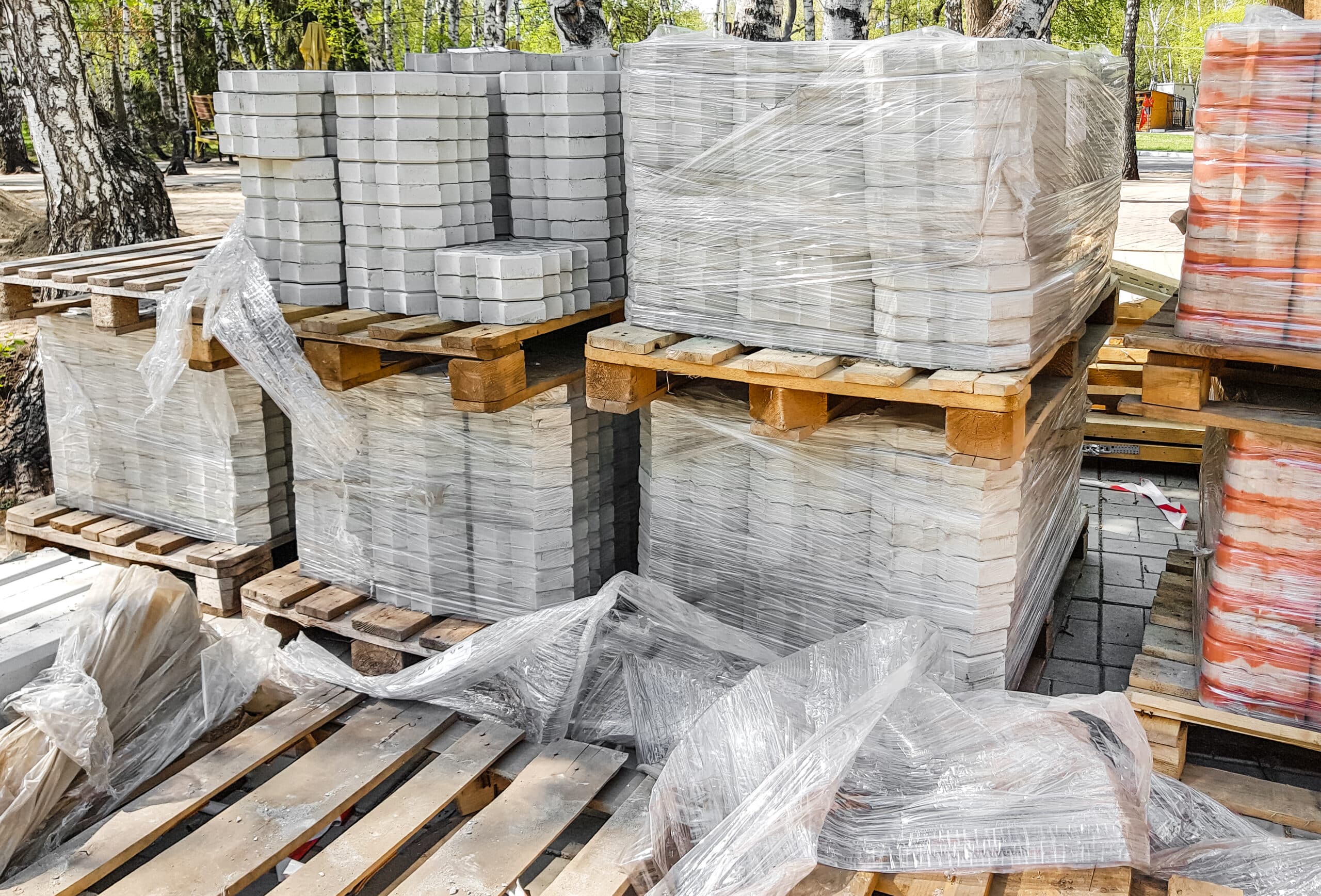 Close-up, the new paving slabs are neatly stacked on pallets. Repair of sidewalks and replacement of paving slabs. Reconstruction of urban infrastructure.