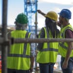 Construction worker talking to man and woman on a construction site