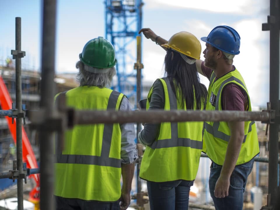 Construction worker talking to man and woman on a construction site