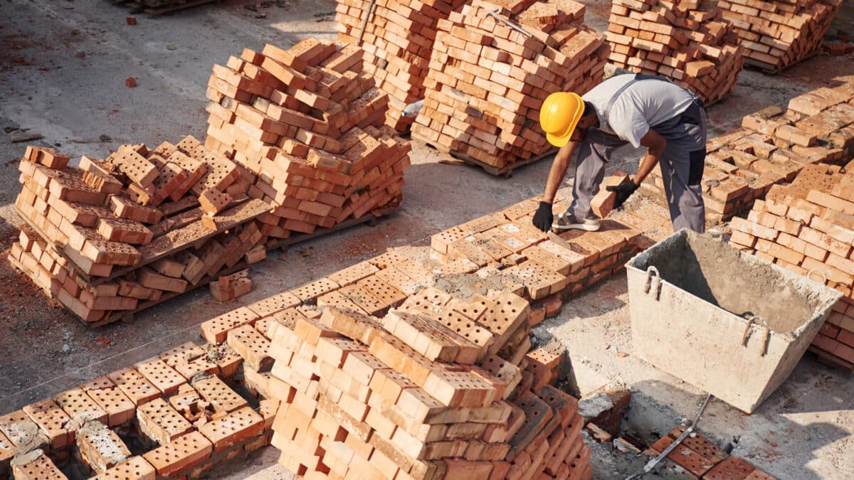 Top view. Handsome Indian man is on the construction site.