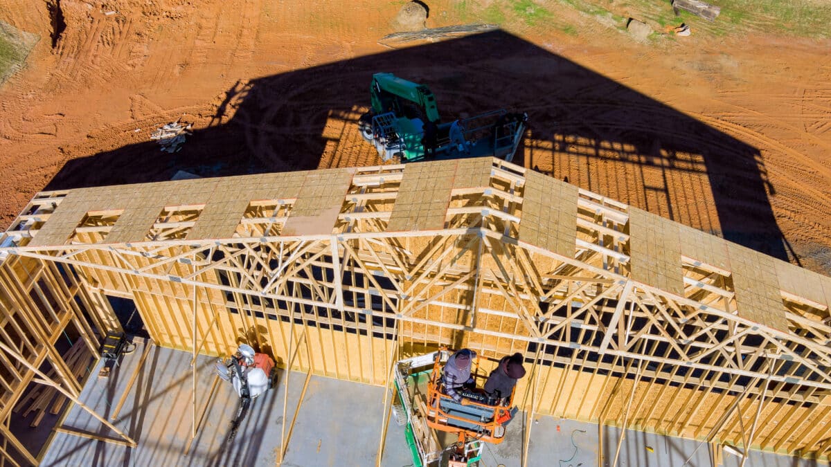 Roofer working with framing installing the roof truss system