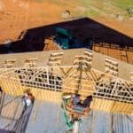 Roofer working with framing installing the roof truss system