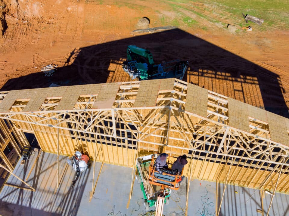 Roofer working with framing installing the roof truss system